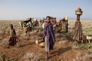 Women and children on the arid plains at the feet of the Mogila mountains in Turkana, northern Kenya. (Credit: IRIN/Gwenn Dubourthoumieu)